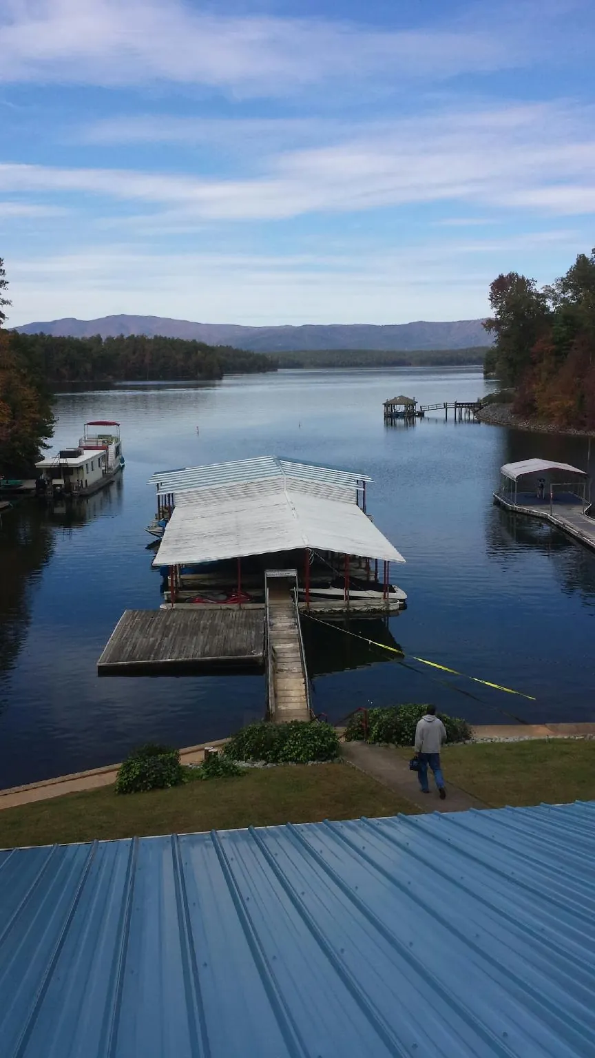 View across a lake from a newly installed blue metal roof in Athens